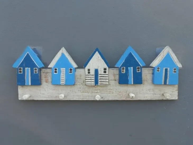 Gantungan baju dinding berhias miniatur rumah